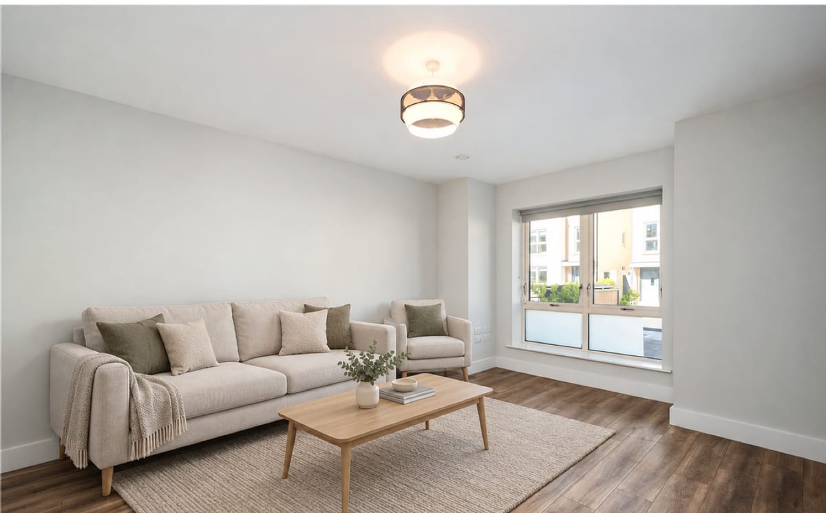 The same living room virtually staged with a sofa, armchair, coffee table and rug, its window and proportions unchanged